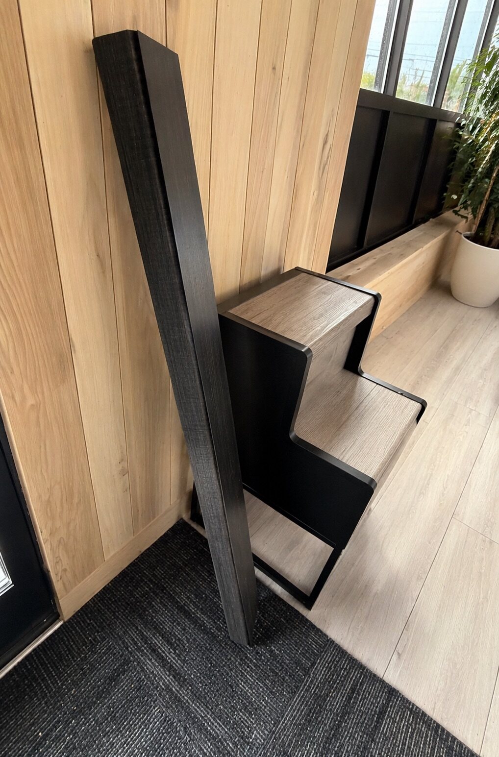 Showroom display of folded vinyl plank stair tread profiles in coordinating colors